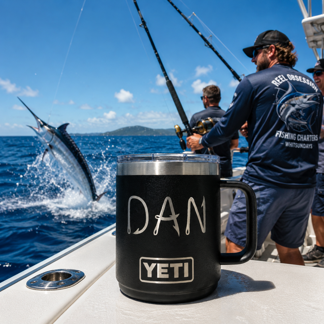 A black YETI handled tumbler with a clear lid sits on the deck of a boat, with a blue and white background showing a man fishing and a marlin jumping in the ocean.